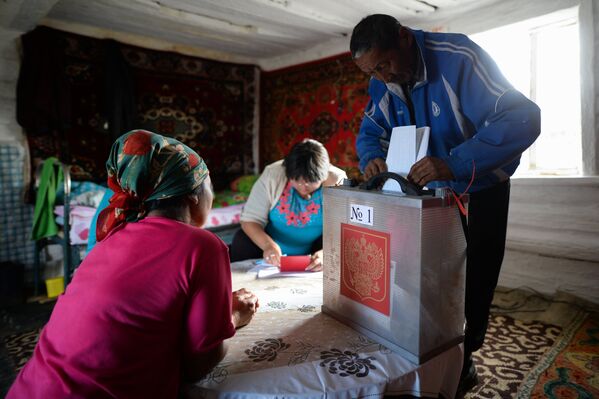 Члены участковой избирательной комиссии и местные жители на животноводческой стоянке в Кош-Агачском районе Республики Алтай во время досрочного голосования на выборах депутатов