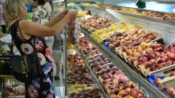 Покупательница у прилавка с фруктами в супермаркете. Архивное фото