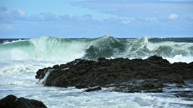 Волны Охотского моря у берега на западе острова Кунашир Большой Курильской гряды. Архивное фото
