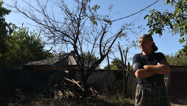 Местный житель осматривает разрушения в результате ночного обстрела Макеевки артиллерией ВСУ