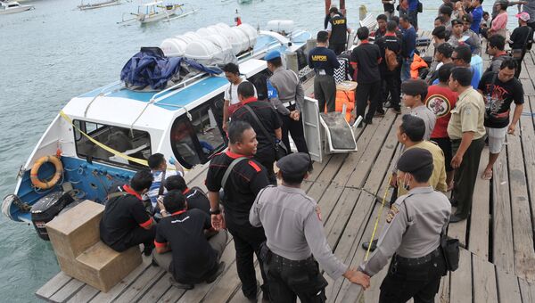 Полицейские осматривают туристический паром, на котором произошел взрыв неподалеку от острова Ломбок в Индонезии