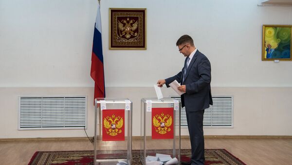 Избиратель голосует в единый день голосования на избирательном участке № 8125 в Российском центре науки и культуры в Астане