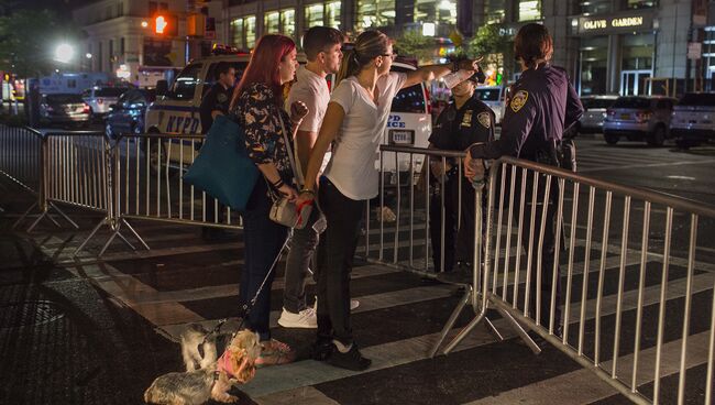 Жители общаются с полицией на месте взрыва в Нью-Йорке.