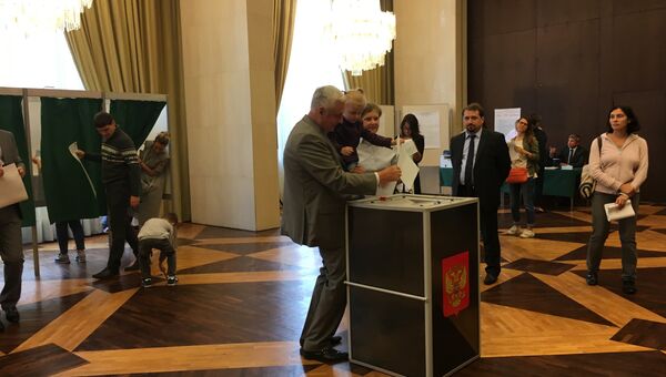 Посол РФ во Франции Александр Орлов с супругой и дочерью голосуют на избирательном участке в Париже