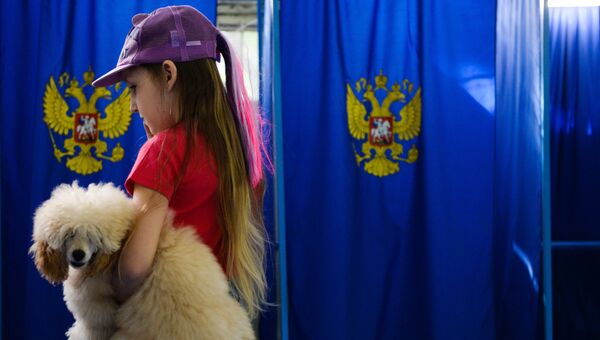 Девочка с собакой в единый день голосования на избирательном участке. Архивное фото