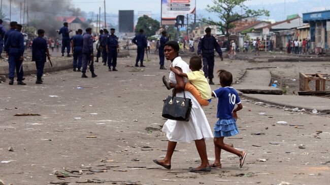 Семья на улице Киншасы во время столкновений представителей оппозиции и полиции. Архивное фото