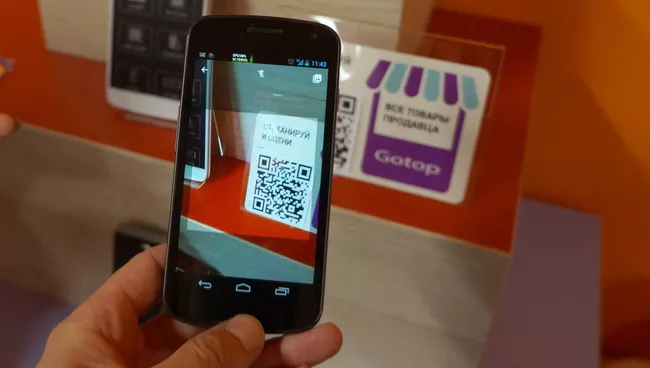 Сканирование QR-кода товара в шоуруме Aliexpress. Архивное фото