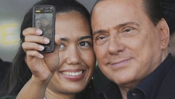 Премьер-министр Италии Сильвио Берлускони фотографируется со сторонницей во время встречи с членами партии Народ свободы
