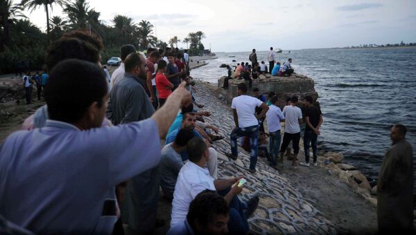 Люди на побережье Средиземного моря в Египте во время спасательной операции на месте крушения судна с мигрантами
