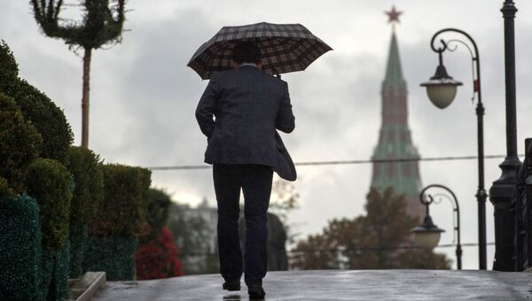 Мужчина на Лужковом мосту во время дождя в Москве
