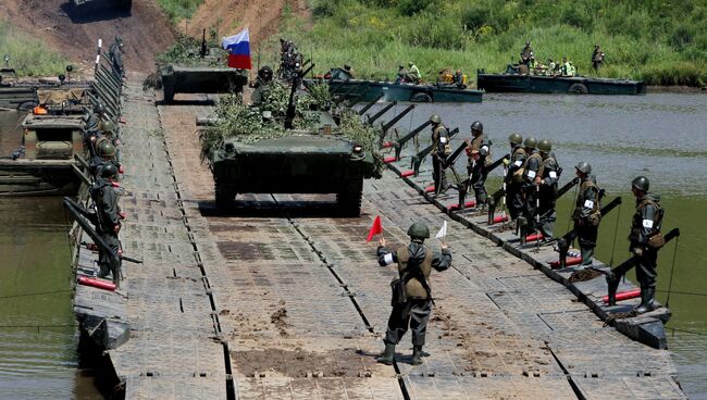 Боевые машины пехоты (БМП-2) преодолевают водную преграду по понтонному мосту в рамках тактических учений мотострелковой бригады, инженерных подразделений 5-й общевойсковой армии Восточного военного округа при поддержке армейской авиации по форсированию водной преграды на Сергеевском полигоне