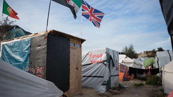 Стихийный лагерь мигрантов в пригороде города Кале на севере Франции