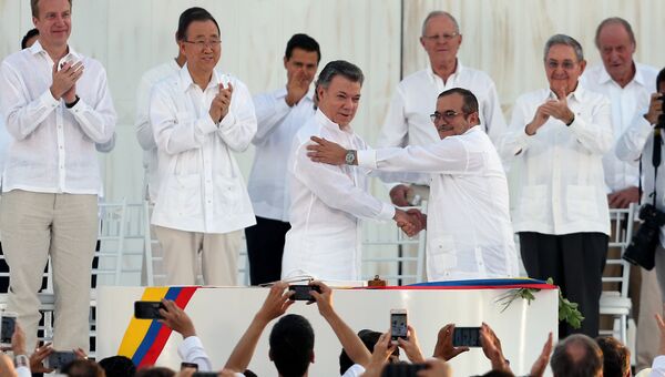 Президент Колумбии Хуан Мануэль Сантос и лидер бывших повстанцев Родриго Лондоньо Эчеверри после подписания соглашения о мире в городе Картахена, Колумбия. 26 сентября 2016