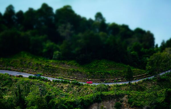 Автомобильная дорога у зеленого и голубого озера Сет Сидадеш на острове Сан-Мигель. Остров входит в состав архипелага Азорские острова в Атлантическом океане