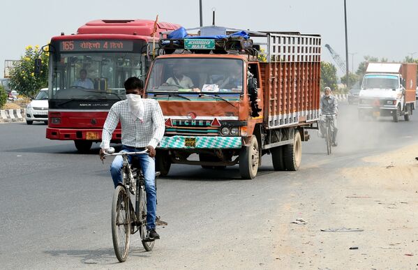 Велосипедист в маске, чтобы защитить себя от загрязненного воздуха в Нью-Дели, Индия