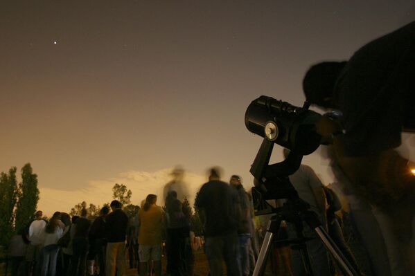 Люди смотрят через телескоп на Марс в Лос-Анджелесе