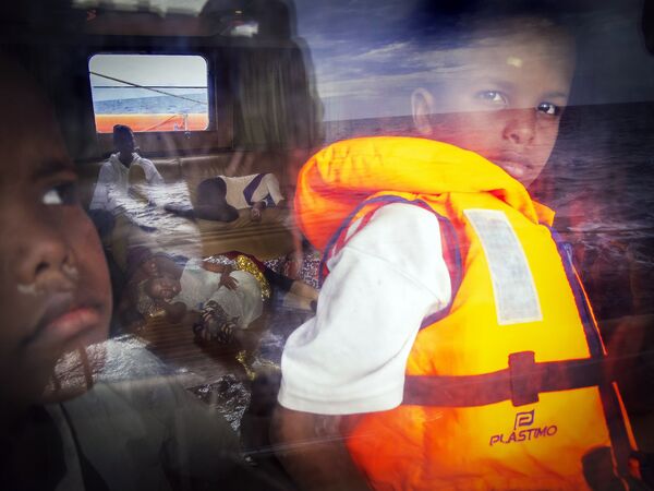 Ребенок из Сомали смотрит в окно на спасательном судне Astral