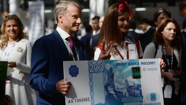 Герман Греф с образцом банкноты в 200 рублей