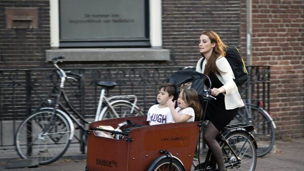 Женщина на велосипеде с детьми на одной из улиц Утрехта