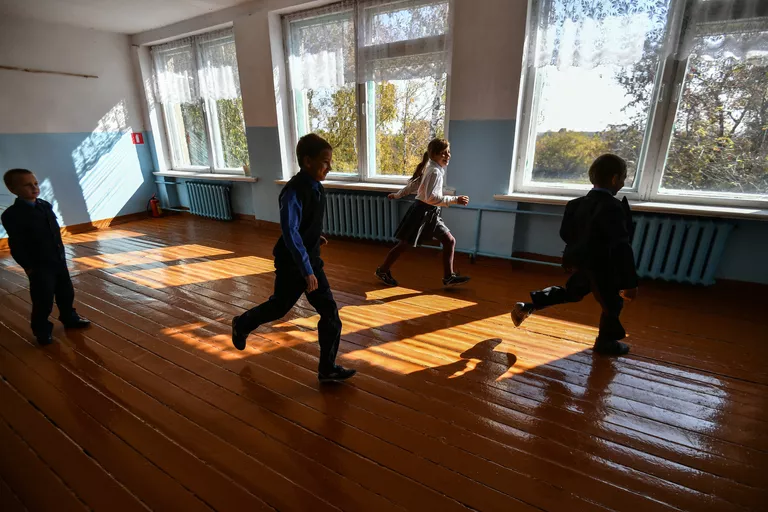 Живущий в приемной семье Сергей (11 лет) и живущая в приёмной семье Аня (12 лет) (в центре) на перемене в школе села Сенное в Брянской области Живущий в приемной семье Сергей (11 лет) и живущая в приёмной семье Аня (12 лет) (в центре) на перемене в школе села Сенное в Брянской области