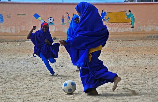 Сомалийские школьницы играют в футбол на территории школы