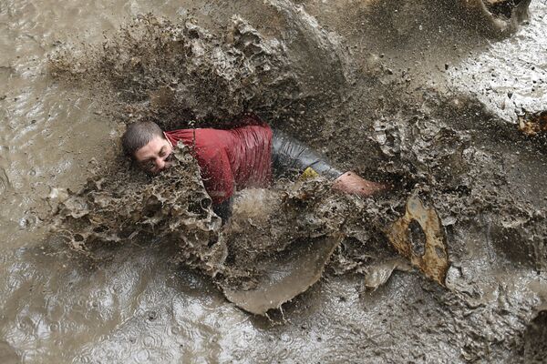 Участник забега в рамках Дня грязи в городе Мериньяк, Франция
