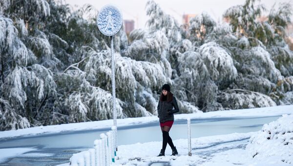Девушка во время снегопада на улице Омска