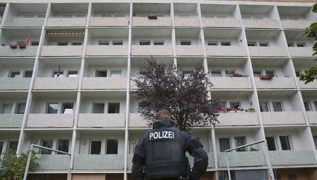 Немецкий полицейский в Хемнице перед домом, который эвакуировали в ходе поисков террориста, 8 октября 2016