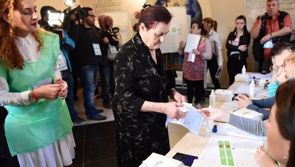 Избиратели голосуют на Парламентский выборах на одном из избирательных участков в Тбилиси