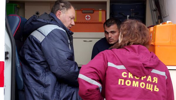 Медработник оказывает помощь спасенным членам экипажа плавучего крана, затонувшего у берегов Крыма, в порту Балаклавы