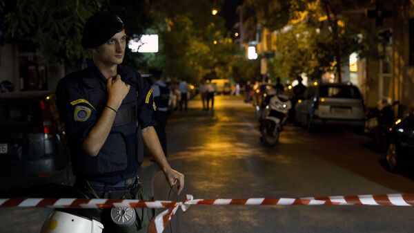 Сотрудник полиции возле места взрыва в Афинах, Греция. 12 октября 2016