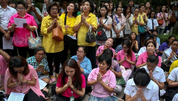 Люди молятся за здоровье 88-летнего короля Таиланда Пхумипхона Адулъядета на территории больницы Сирират в Бангкоке. 12 октября 2016