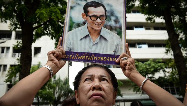 Женщина с портретом короля Таиланда Пхумипхона Адулъядета на территории больницы Сирират в Бангкоке. 13 октября 2016