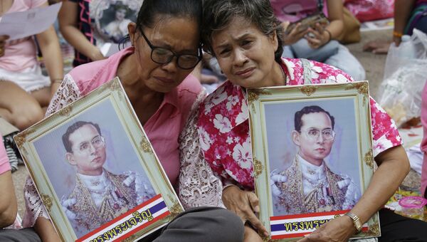 Женщины с портретами короля Таиланда Пхумипхона Адулъядета в Бангкоке. Архивное фото