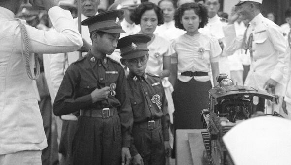 Король Таиланда Пхумипон Адульядет и его брат Ананда Махидон рассматривают подаренную им игрушечную модель поезда, Бангкок. 1938 год