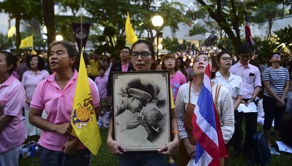 Женщины с портретом короля Таиланда Пхумипхона Адулъядета в Бангкоке. 13 октября 2016