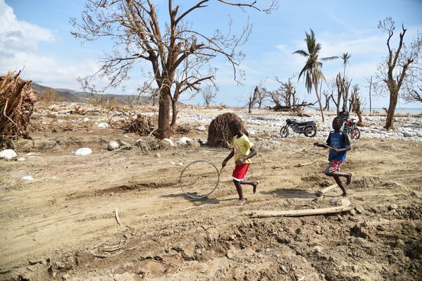 Дети играют на улице Гаити после урагана Мэтью