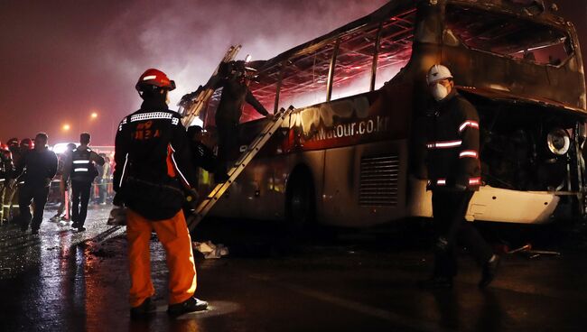 Спасатели на месте пожара в автобусе на автомагистрали недалеко от города Ульсан в Южной Корее. 14 октября 2016