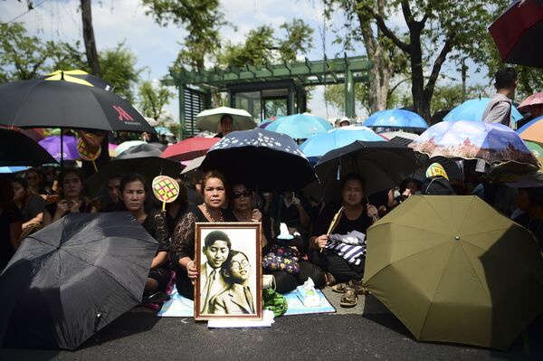 Люди на пути кортежа везущего тело короля Таиланда Пхумипона Адульядета в Бангкоке, Таиланд