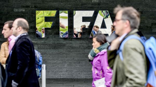 Люди идут мимо здания Международной федерации футбола (ФИФА) в Цюрихе