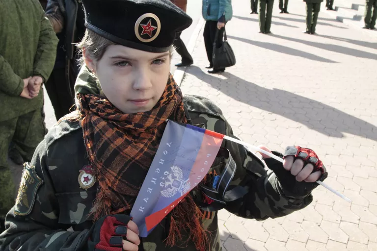 Жительница Донецка Ангелина с флажком, на котором ей оставил автограф командир ополчения ДНР Арсен Павлов (Моторола), на церемонии прощания с А. Павловым Жительница Донецка Ангелина с флажком, на котором ей оставил автограф командир ополчения ДНР Арсен Павлов (Моторола), на церемонии прощания с А. Павловым