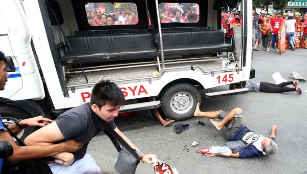 Полицейский автомобиль сбил демонстрантов во время акции протеста у здания посольства США в Маниле. 19 октября 2016