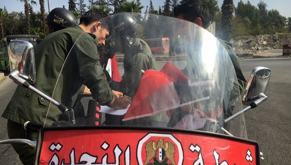 Сотрудники полиции готовятся к выходу мирных граждан и боевиков из восточного Алеппо