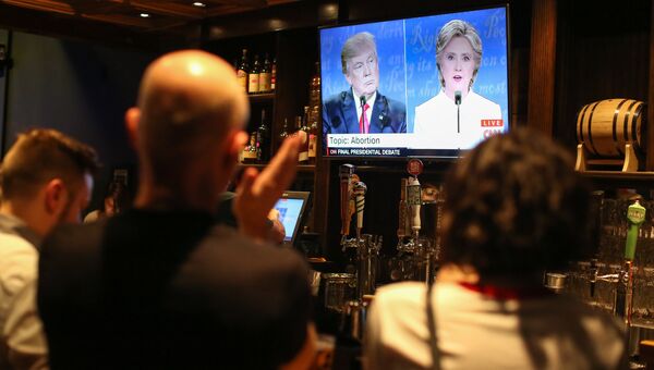 Люди смотрят трансляцию дебатов между Дональдом Трампом и Хиллари Клинтон. Архивное фото