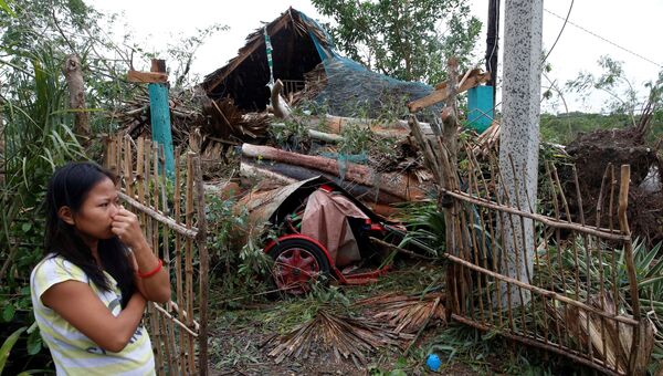 Женщина у разрушенного дома после тайфуна Лавин на Филиппинах. 20 октября 2016