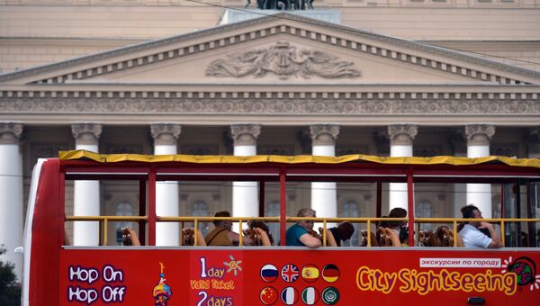 Туристы проезжают на экскурсионном автобусе мимо Большого театра в Москве. архивное фото
