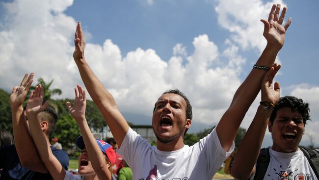 Студенты выкривают лозинуги против президента Венесуэлы Николаса Мадуро в Каракасе