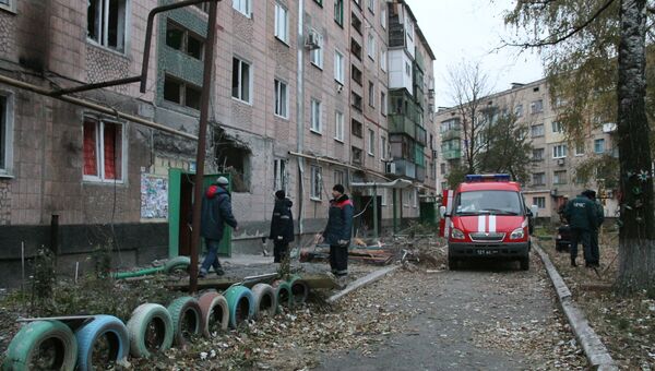 Сотрудники МЧС и коммунальных служб у жилого дома, пострадавшего в результате обстрела украинскими силовиками, в Макеевке