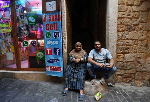 Хозяева на пороге своего магазина на улице в ливанском городе Сайда