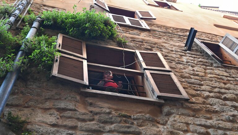 Мальчик в окне своего дома в ливанском городе Сайда